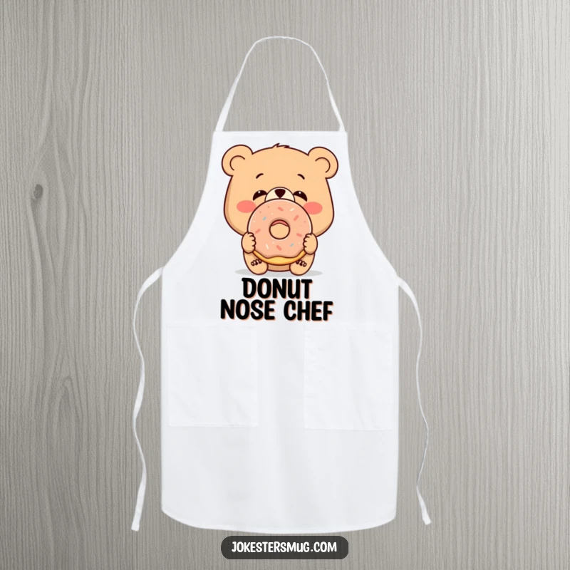 Funny cooking apron featuring a bewildered bear with a donut stuck to its nose, kitchen humor.