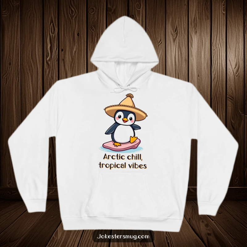Funny hoodie showing a penguin wearing a sombrero, attempting to surf on a precarious ice floe, a humorous winter sports character.