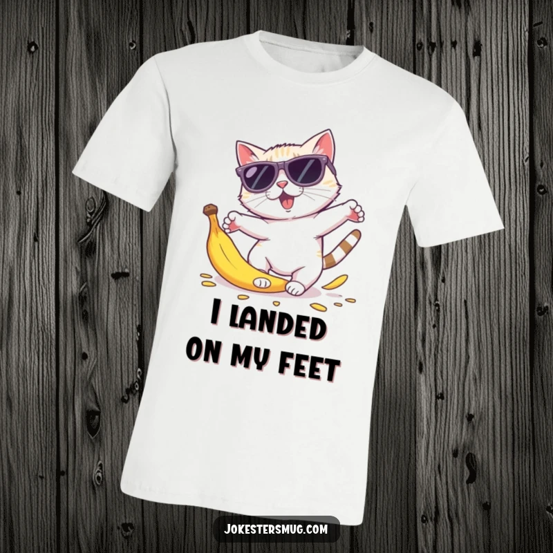 Funny cat sunglasses t-shirt depicting a feline in oversized shades tripping over a banana peel, body parts flying comically.